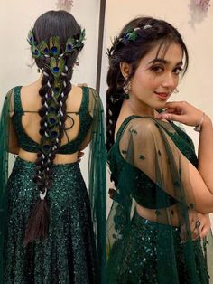 a woman with long hair wearing a green dress and peacock feathers on her head, standing in front of a mirror