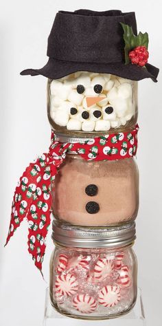 a snowman made out of mason jars filled with marshmallows and candy canes