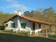 a small white house with green shutters on the windows