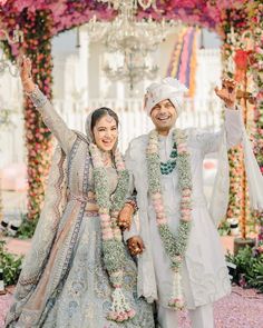 two people dressed in wedding attire standing next to each other