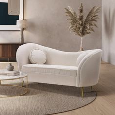 a living room with a white couch, coffee table and rug on the floor in front of it