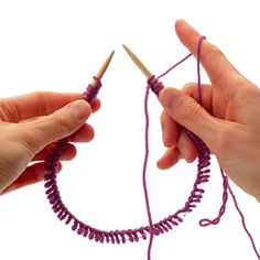 two hands are holding yarn and crochet hooks to hook the ends of thread