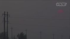 the sun is setting over power lines and telephone poles on a foggy day,