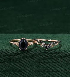 two rings with black stones on green cloth