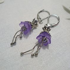 These fun little Frosted Purple Flower Earrings, are made from Glass, Stainless Steel, Acrylic, and Antique Silver Accents. They dangle approximately 1 1/8" from Hypoallergenic Stainless Steel Leverback Earwire.  If you prefer French earwire, please let me know! Whimsical Adjustable Flower Charm Earrings, Whimsical Dangle Flower Earrings, Adjustable Purple Flower Earrings For Gift, Adjustable Purple Flower Earrings As Gift, Whimsical Purple Nickel-free Earrings, Whimsical Nickel-free Purple Earrings, Whimsical Nickel Free Dangle Flower Earrings, Whimsical Adjustable Nickel-free Flower Earrings, Whimsical Flower-shaped Hypoallergenic Jewelry