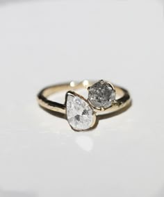 two pear shaped diamond rings sitting on top of each other