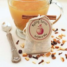 a cup of mulled spice next to a spoon and bag with cinnamons on it