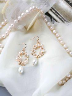 pearls and other jewelry are laying on a white cloth