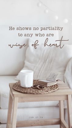 a coffee table with a book and cup on it next to a white couch that says, he shows no partiality to any who are wise of heart