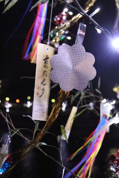 a close up of a tree with lights in the background and decorations hanging from it's branches