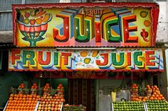 a fruit juice stand in front of a building