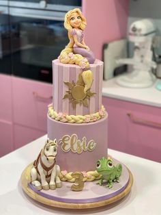 there is a cake that has a princess on top and two animals around the bottom