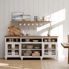 a kitchen with white cabinets and wooden shelves filled with plates, bowls and utensils