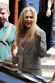 a woman with long blonde hair walking down the street