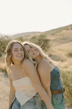 two young women hugging each other in the desert