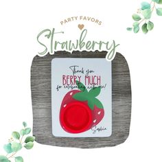 a strawberry shaped magnet with the words strawberry on it's back and green leaves around it