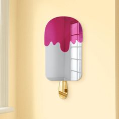 an ice cream cone shaped mirror mounted to the side of a wall next to a window