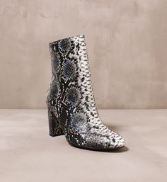 Snake room in your closet and let these boots slither on in. These statement boots by Chinese Laundry feature a multi-toned python print with pops of color to add dimension. With a block heel, an almond toe, and a side zipper, these shoes exude fun energy in a classic silhouette. 3.5" Heel l Manmade Materials l True to Size Fall Snake Print Ankle Boots, Trendy Snake Print Ankle Boots, Snake Print Boots With Round Toe And Medium Width, Snake Print Boots With Medium Width And Round Toe, Snake Print Boots With Medium Width, Black Snake Print Ankle Boots, Fall Round Toe Heeled Boots With Snake Print, High Heel Snake Print Boots For Fall, Snake Print Heeled Boots With Round Toe For Fall