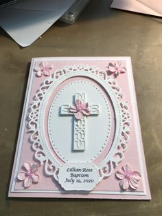 a pink and white card with a cross in the center on it's side