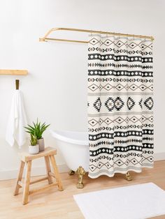 a white bath tub sitting next to a wooden stool and shower curtain in a bathroom