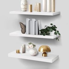 two white shelves with books and plants on them