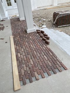 a brick walkway is being built in front of a house