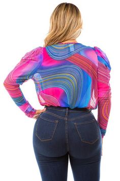 a woman in high waist jeans and a colorful shirt is looking back at the camera