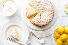 there is a lemon cake on the table with other plates and bowls next to it