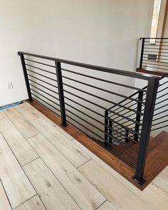 an empty room with wood flooring and metal railing