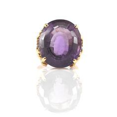 "Thrill that February birthday girl with this gorgeous ring! This exquisite 14 karat solid yellow gold ring is prong-set to the center with one oval-cut natural amethyst measuring 23.16 millimeters long by 19.53 millimeters wide by 14.13 millimeters deep and weighing an estimated 32.45 carats. The amethyst is accented with six round full-cut natural diamonds, each measuring 1.5 millimeters in diameter, and each weighing an estimated 0.015 carats, for a total diamond weight 0.09 carats, and a tot 14k Gold Oval Amethyst Ring With Accent Stones, Oval Amethyst Ring With Accent Stones In 14k Gold, Oval Amethyst Ring In 14k Yellow Gold, Oval Amethyst Ring In 14k Gold, Fine Jewelry Oval Amethyst Ring In 14k Gold, Oval Amethyst Ring With Accent Stones In Yellow Gold, Oval Yellow Gold Amethyst Ring With Accent Stones, Elegant 14k Gold Oval Amethyst Ring, Yellow Gold Oval Amethyst Ring With Prong Setting