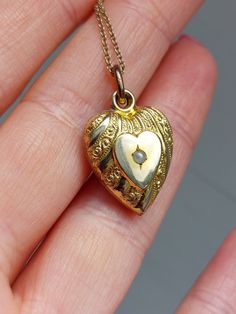 Sweet little heart pendant with a seed pearl. The pearl is set at the center of the front facet. There is a textured ornament at the outer edge of the heart. The back is plain.  Details: The pendant is not stamped and likely made of a gold plated metal. It is in very good antique condition with no dent, gentle surface wear and some gold plating loss at the back, please inspect the photos. It comes with a new 18" gold filled chain that is stamped 14/20 GF at the clasp.. Measurements: -Chain: 45cm Antique Heart Locket Necklace For Formal Occasions, Victorian Heart-shaped Jewelry For Anniversary, Victorian Heart-shaped Necklace For Anniversary, Victorian Heart-shaped Necklace For Formal Occasions, Victorian Heart Necklace For Formal Occasions, Victorian Heart-shaped Formal Necklace, Vintage Heart Bead Pendant Jewelry, Heart Pendant Necklace With Pearl Charm For Anniversary, Formal Heart Locket Necklace