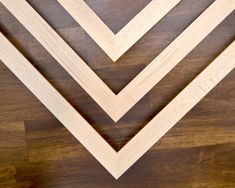 three pieces of wood sitting on top of a wooden floor