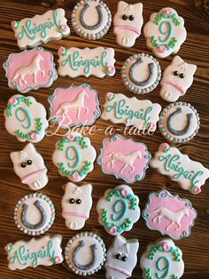 decorated cookies are arranged on a table with the names and numbers in blue, pink, and white