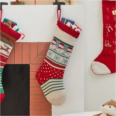 two stockings hanging on the wall next to a teddy bear and other christmas stocking