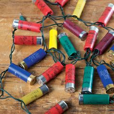 an assortment of batteries and wires on a wooden surface with string lights attached to them