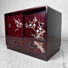 an old wooden cabinet with flowers painted on it