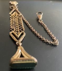 Offered is an outstanding and unique pocket watch chain fob circa 1890's. T The links are strong and attractive! The end hook and swivel are strong and mechanically sound and will securely hold your time piece or locket for many years to come.  As you can see from the picture, the item has a lovely coat or patina that took over 120 years to form. Many people appreciate their antique jewelry with this lovely coating (myself included); however, some prefer a shinier piece. Please know that we never polish antique jewelry as it is an individual decision.  Currently, the item is dull with patina and quite tarnished. It will arrive this way, and it is your decision to either keep its coat of patina or have it polished to a yellow gold color. As stated above, it is an individual decision to poli Antique Gold Pocket Watch With Locket For Formal Occasions, Formal Antique Gold Pocket Watch With Locket, Antique Gold Locket Pocket Watch For Formal Occasions, Antique Formal Jewelry Chain, Antique Style Formal Jewelry Chain, Antique Chain Jewelry For Formal Occasions, Victorian Style Formal Jewelry With Chain, Formal Antique Jewelry With Chain Details, Antique Wedding Jewelry Chain