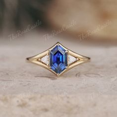 a blue and white diamond ring sitting on top of a table