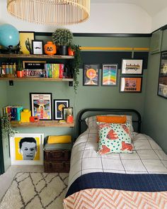 a bed room with a neatly made bed and lots of books on the shelves above it