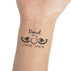 a small wrist tattoo with the name david and wings on it's left arm