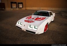 a white car with red and white graphics on it's hood parked in a parking lot