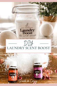 three bottles of laundry scent sitting on top of a wooden table next to an empty jar