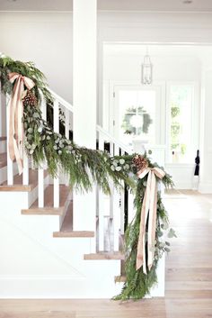 christmas garland on the stairs with pine cones and greenery