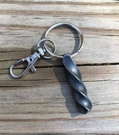 a metal keychain that is on top of a wooden table with a pair of scissors