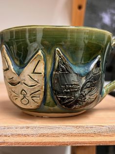 a green cup with two cats on it