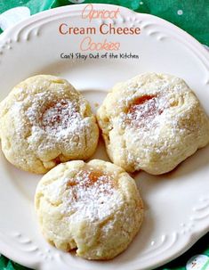 three powdered sugar cookies on a white plate