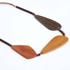 Three geometric wood beads make up this neutral palette statement necklace. The large wood beads are accented with small beads between each and finished off with bar beads topped with a silver ball bead. The necklace hangs on an adjustable brown wax cord. The neutral palette makes this necklace easy to pair with any outfit. Adjustable length: 24″-28″ Largest bead: 3.5″L x 1″ W Wood Jewelery, Small Beads, Beaded Top, Neutral Palette, How To Make Beads, Wood Beads, The Necklace, Natural Wood, Statement Necklace