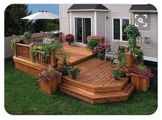 a wooden deck surrounded by potted plants and flowers