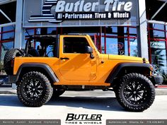 a yellow jeep is parked in front of a building