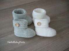 two crocheted baby boots sitting on top of a wooden floor